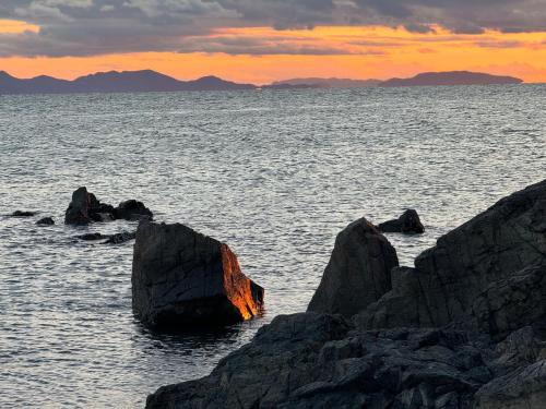 a group of rocks in the water at sunset at Donkairo in Ako