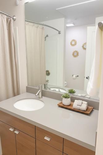 a bathroom with a sink and a mirror at Ocean Breeze Marina Suites with Pool, Gym & Hot Tub in Los Angeles