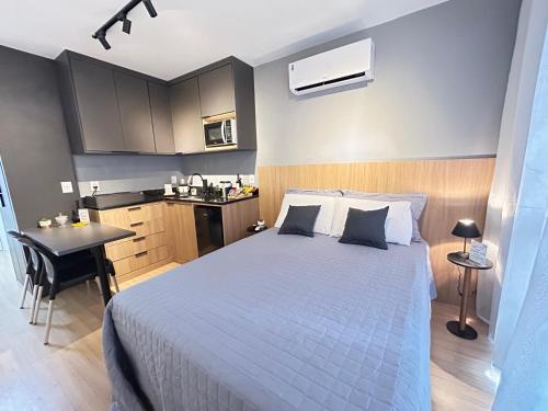 a bedroom with a bed and a kitchen with a table at Studio moderno e novo - Uni Home 405 - Boa Viagem in Niterói