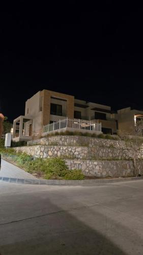 a house with a stone wall next to a street at Sifah Ocean Breeze Villa in Muscat