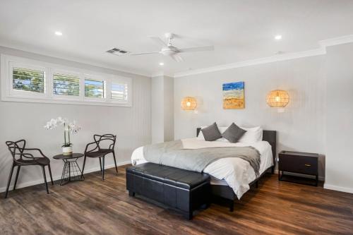 Un dormitorio con una cama y una mesa y sillas. en Ava Del Mar - Luxury at Jervis Bay, en Callala Beach