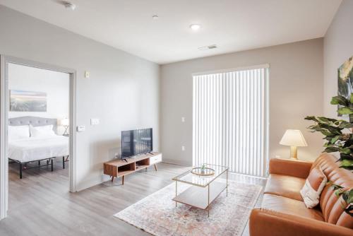 a living room with a couch and a tv and a bed at CozySuites at Current the Banks gym pool 01 in Cincinnati