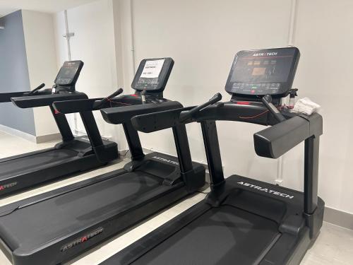 a gym with three treadmills with cell phones on them at Studio moderno e novo - Uni Home 405 - Boa Viagem in Niterói