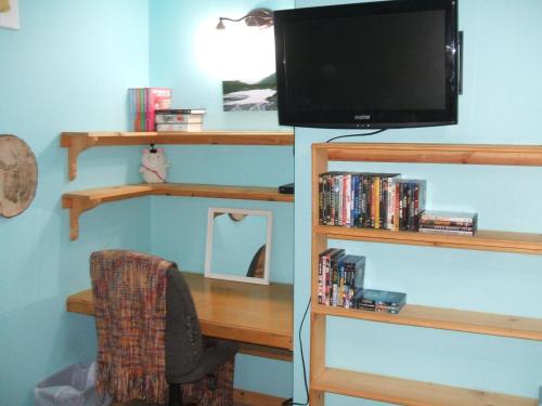 a desk with a television and a desk with a chair at Cook's Place in Tok