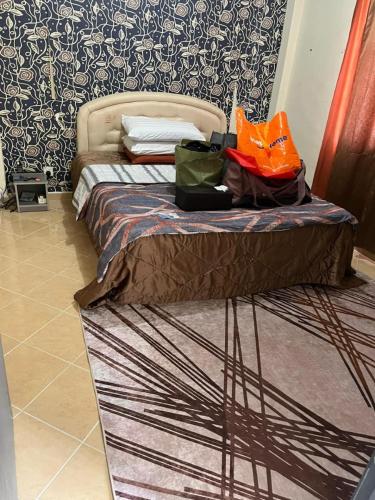 a bed with bags on it in a room at RumahCheMatsunami in Tanah Rata