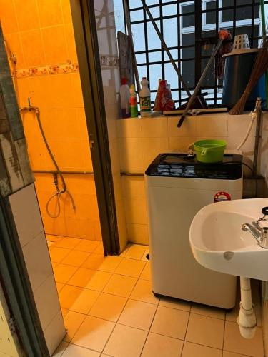 a bathroom with a sink and a stove at RumahCheMatsunami in Tanah Rata