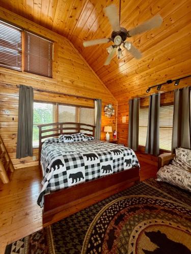 Un dormitorio con una cama y un ventilador de techo. en Spacious Cabin -View, Pool Table, Arcade & Hot Tub, en Sevierville