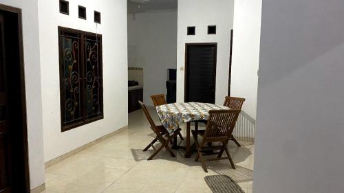 a dining room with a table and four chairs at Cosinus Purwosari in Kejayan