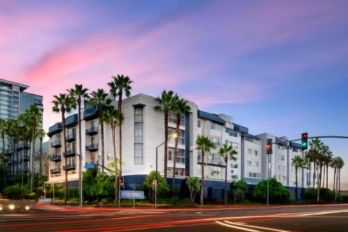 a building with palm trees in front of a street at Ocean Breeze Marina Suites with Pool, Gym & Hot Tub in Los Angeles