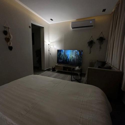 a bedroom with a bed and a flat screen tv at Amal Hotel in Riyadh