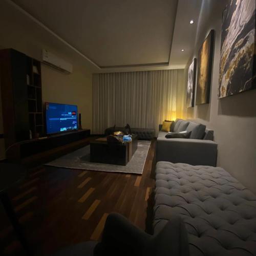 a living room with a couch and a tv at Amal Hotel in Riyadh