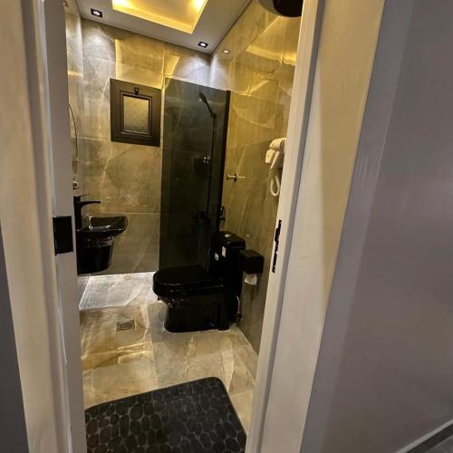 a bathroom with a black toilet and a sink at Amal Hotel in Riyadh