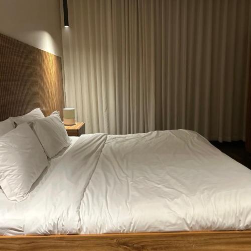 a large white bed with white sheets and pillows at Amal Hotel in Riyadh