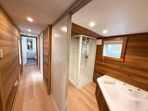 ハンマー・スプリングスにあるDelight on Devonの木製の壁のバスルーム(バスタブ付)