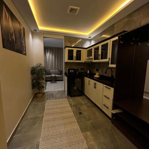 a kitchen with white cabinets and a sink and a table at Amal Hotel in Riyadh