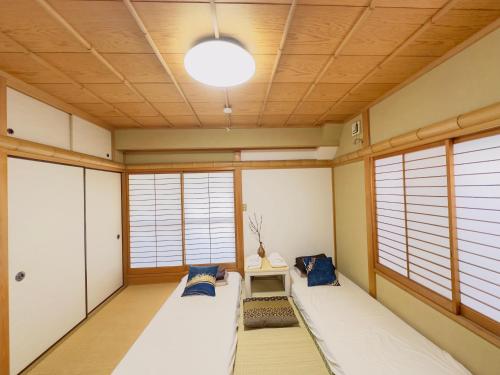 a room with two beds in a room with windows at 東京雅麗館 in Tokyo