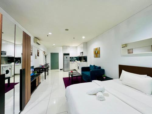 a bedroom with a bed and a living room at Luxury Mercu Summer Suites KLCC By JT in Kuala Lumpur