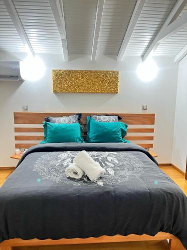 a bedroom with a large bed with blue pillows at P'ti Paradise in Le Gosier