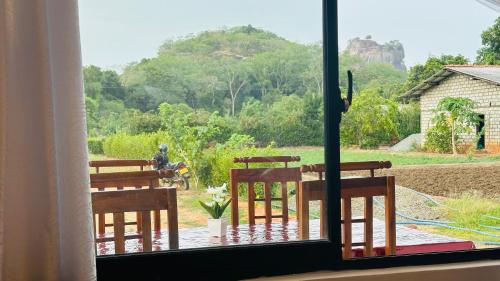 Una ventana con sillas y vista a una montaña. en Sigiri Rock View Lodge, en Sigiriya