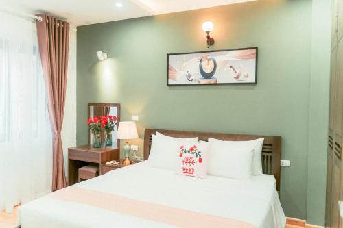 a bedroom with a bed and a tv on the wall at Moon Hotel Apt Phạm Tuấn Tài in Hanoi