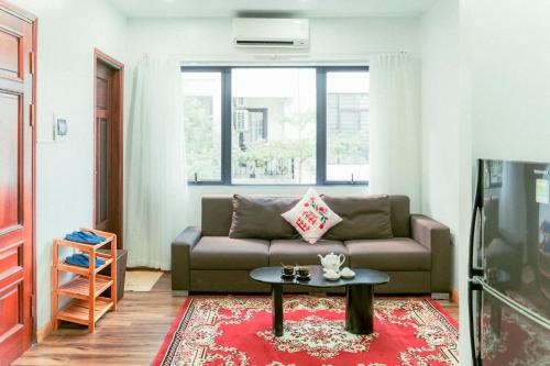 a living room with a couch and a table at Moon Hotel Apt Phạm Tuấn Tài in Hanoi
