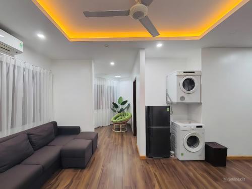 a living room with a couch and a washing machine at Moon Hotel Apt Phạm Tuấn Tài in Hanoi