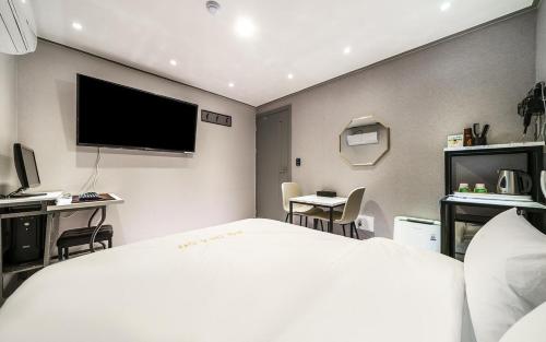 仁川にあるon&offのベッドと薄型テレビがあるホテルの部屋