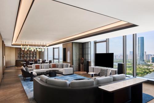 a lobby with couches and a flat screen tv at Sheraton Grand Xiamen Jimei in Xiamen