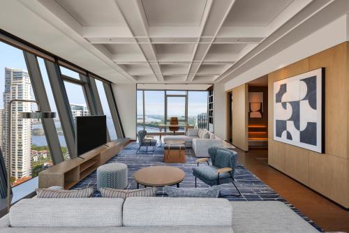 a living room with couches and a flat screen tv at Sheraton Grand Xiamen Jimei in Xiamen