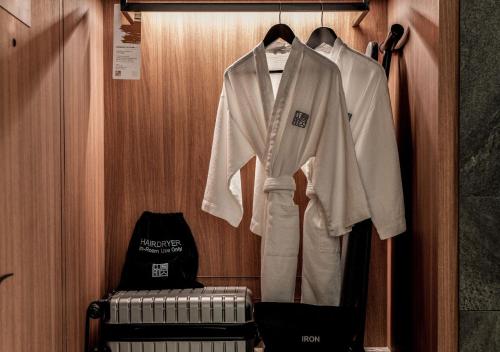 a wardrobe with a white shirt and trousers on a rack at The Clan Hotel Singapore by Far East Hospitality in Singapore