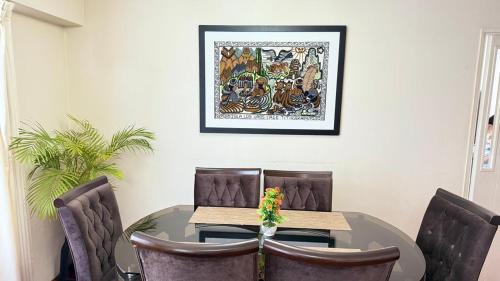 a dining room table with chairs and a picture on the wall at The Legends Family Apartment in Lima