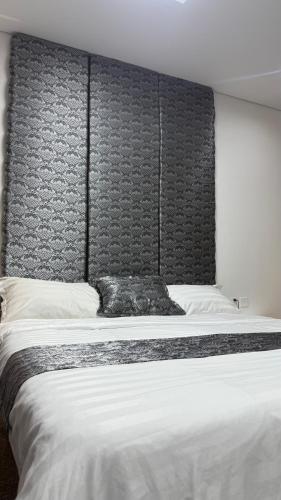 a large bed with a black headboard in a room at Executive 2 bedroom apartment-king size bed steps from Chinggis khan square in Ulaanbaatar