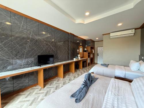 a hotel room with two beds and a tv at Kai Bae Beach Resort Koh Chang in Ko Chang