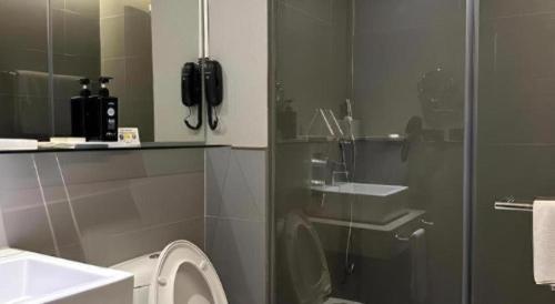 a bathroom with a toilet and a glass shower door at F1 Hotel Manila in Manila