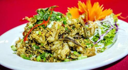 a white plate of food on a red table at Phi Phi Banyan Villa in Phi Phi Don