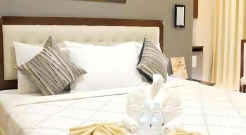 a bedroom with a white bed with two pillows at Devera Hotel in Angeles