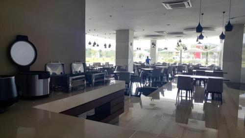 a dining room with tables and chairs in a restaurant at Wing Hotel Kualanamu Airport in Medan