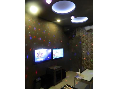 a room with two televisions and a wall with balloons at Wing Hotel Kualanamu Airport in Medan