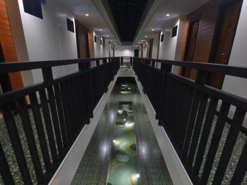 a long hallway with a pond of water with algae at The Green Hotel in Ko Lipe