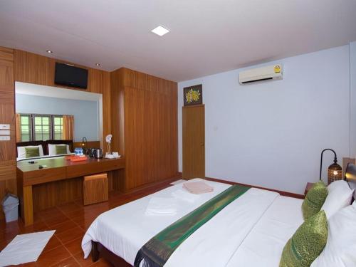 a bedroom with a bed and a bathroom with a sink at The Green Hotel in Ko Lipe