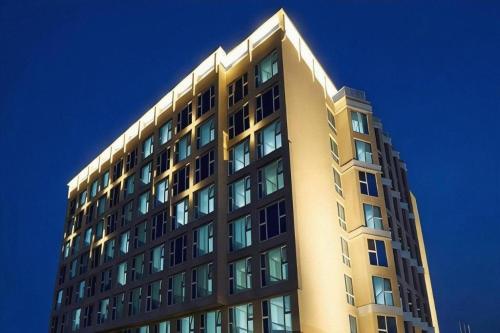 a tall yellow building with many windows at Ebenezer Hotel in Jeju