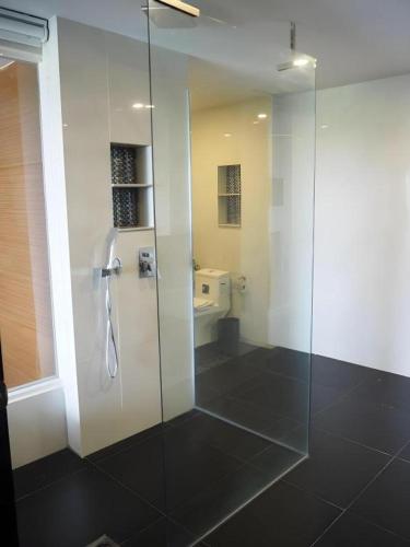 a bathroom with a glass shower and a toilet at The Vista Hotel By Satit Group in Sadao