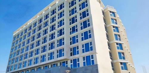 a tall building with blue windows on the side of it at Ebenezer Hotel in Jeju