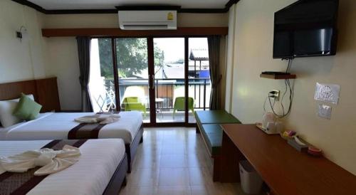 a hotel room with two beds and a television at The Green Hotel in Ko Lipe