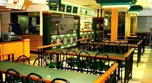 a restaurant with tables and chairs in a cafeteria at The CentrePoint Hotel in Bandar Seri Begawan