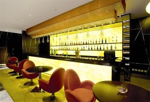 a bar with red chairs and a display of wine bottles at Grand Lisboa Macau in Macau