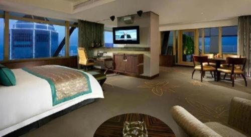 a hotel room with a bed and a living room at Grand Lisboa Macau in Macau
