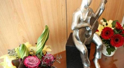 a statue of a rabbit sitting on a table next to flowers at Plaza Sutera Biru Hotel in Kuala Belait