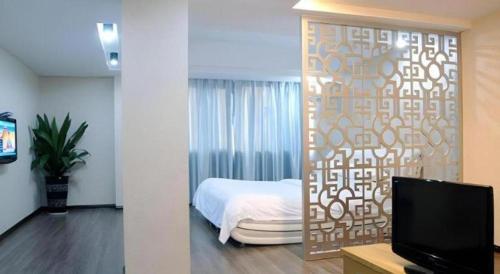 a bedroom with a bed and a wall with a screen at Super 8 Hotel Fuzhou Jinjishan in Fuzhou