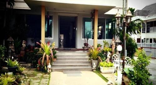 a house with stairs and plants in front of it at Loei Orchid Hotel in Loei